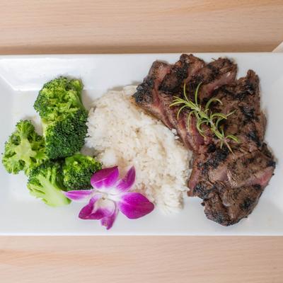 Marinated and grilled flank steak, served with rice, and broccoli.