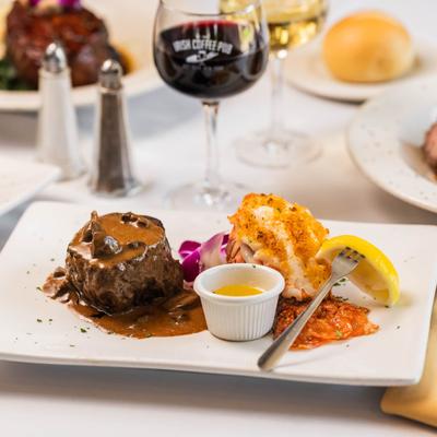 Surf and turf, filet mignon with mushroom sauce, drawn butter, and lobster tail.