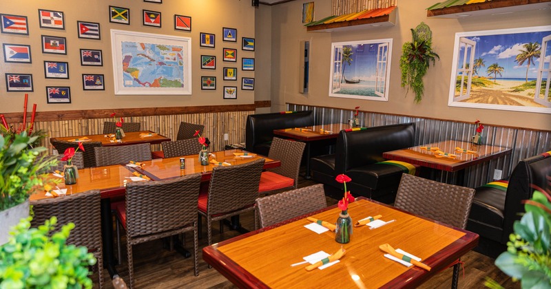Cozy Caribbean-themed restaurant with colorful flags and beach murals
