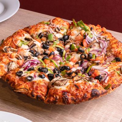 Veggie pizza topped with mushrooms, black olives, peppers, and onions.