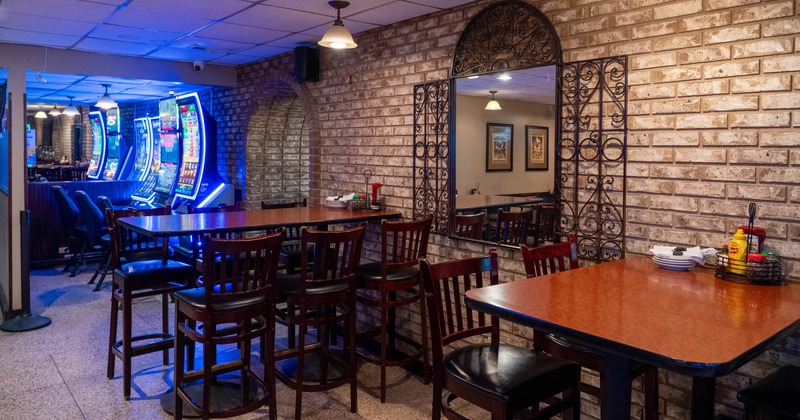 Interior of a dining area with brick walls, mirror, tables