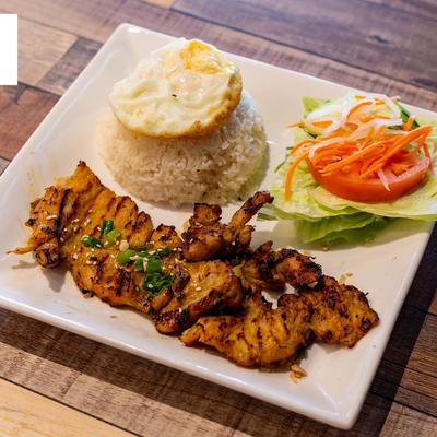 Grilled chicken served with salad and rice.