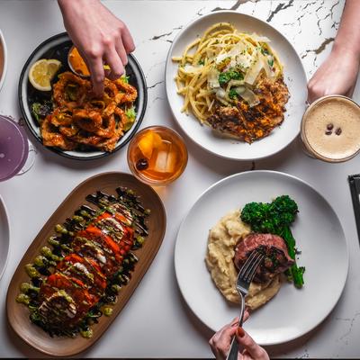 Various dishes served on the table with cocktails.