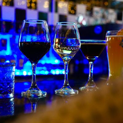 Row of wine and cocktail glasses on a bar top.