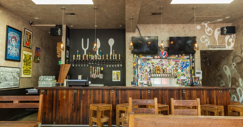 Interior, dining room and bar, table and chairs, sign on the wall between TV screens