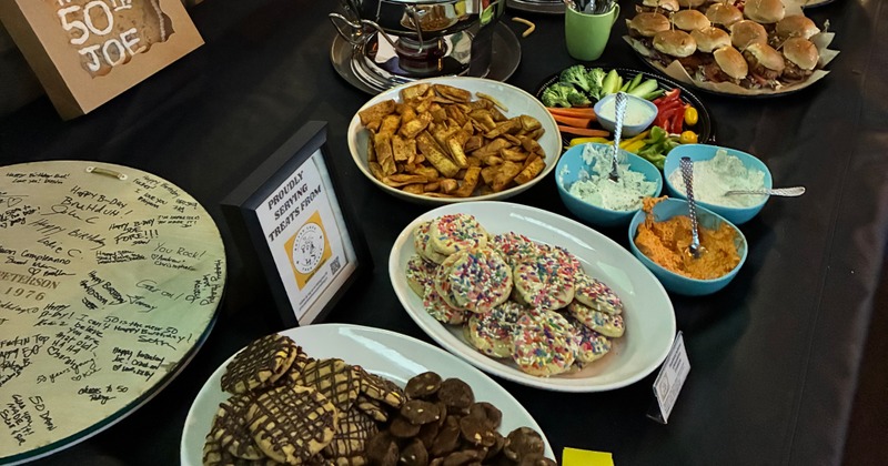 Party spread with various snacks, appetizers, cookies, and several bowls of dips
