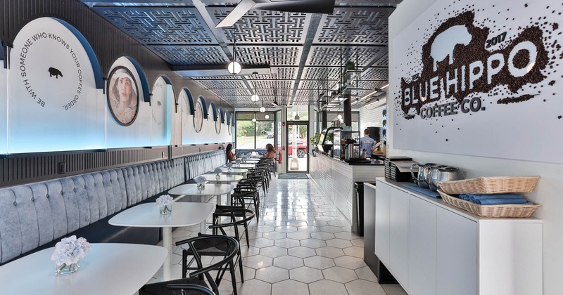 Interior, dining area with banquette bench, tables and chairs on the left, bar on the right