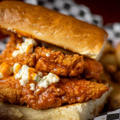 Close up of a crispy buffalo chicken, topped with blue cheese crumbles.