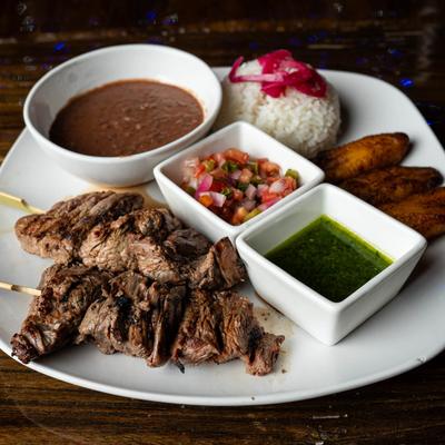 Steak Skewers served with beans, pico de gallo, green salsa, plantains and rice.