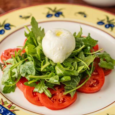 Tomato salad with fresh greens and a creamy cheese ball.
