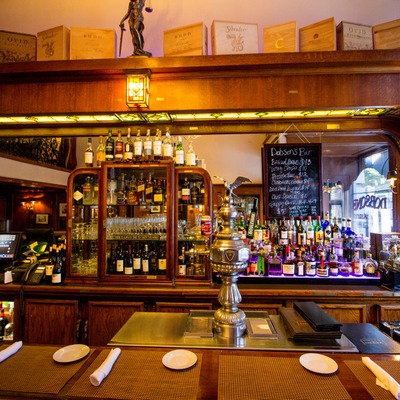 Bar interior with a menu board, liquor bottles, and beer taps.