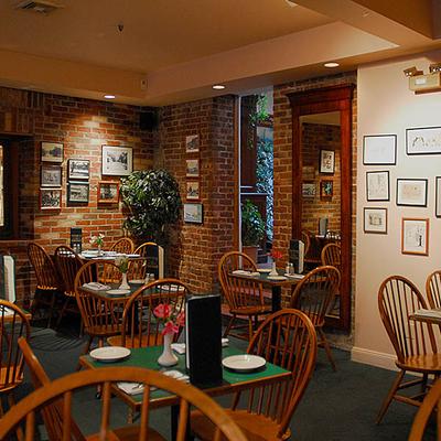 Interior with brick walls, set tables, and wall art.