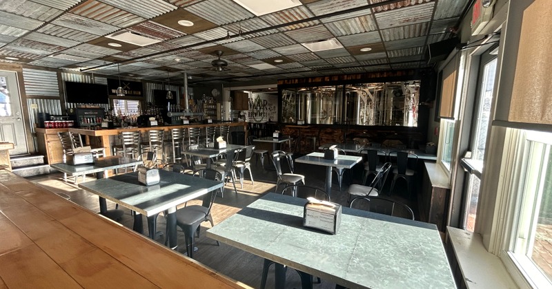 Seating area with tables, chairs, and a bar