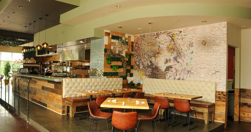 Interior, food counter and seating area by a wall decorated with mural