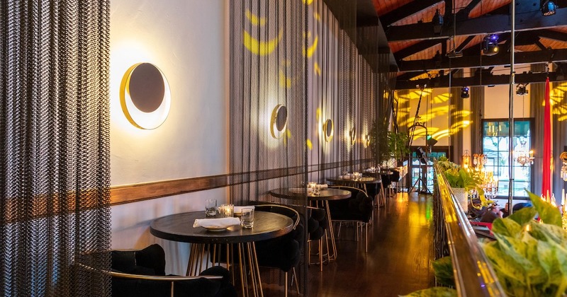 Upstairs, tables and seats by a wall with circular ring shaped lights