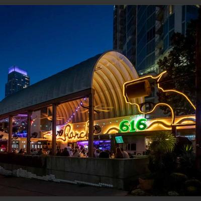 Neon-lit restaurant exterior at night with colorful signage.