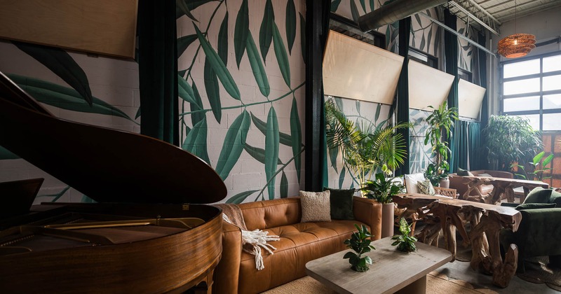 Interior, lounge area, stage piano, two seater sofa with coffee table, plant decoration