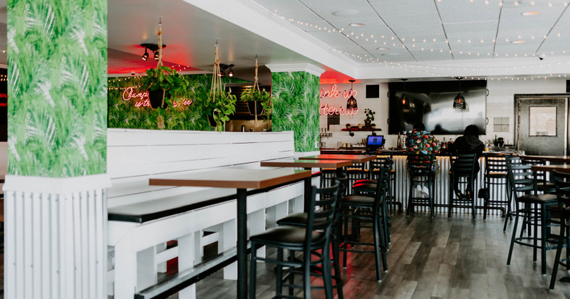 Interior, guest tables, two guests sitting at the bar