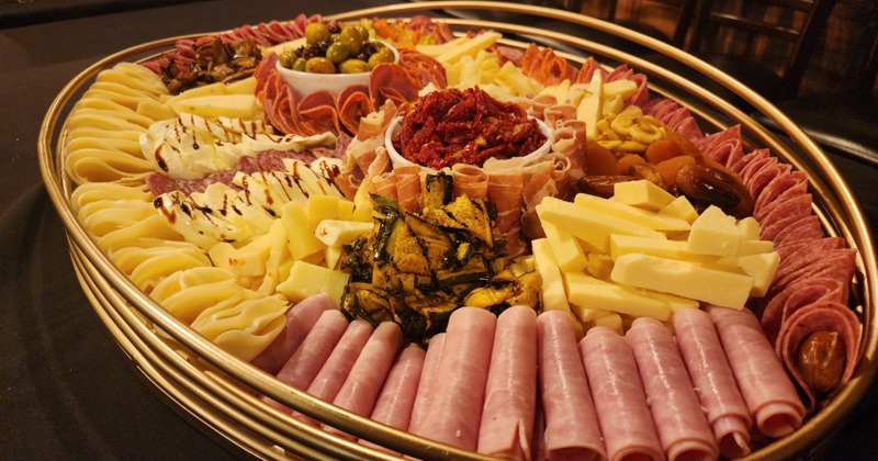 Densely arranged charcuterie and cheese on a round plate