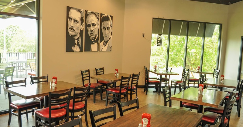 Interior, dining tables and seats, triptych painting of the actors from the Godfather movie
