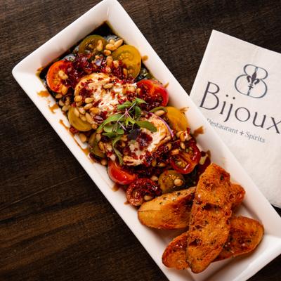 Burrata with tomatoes, olives, and toasted bread.