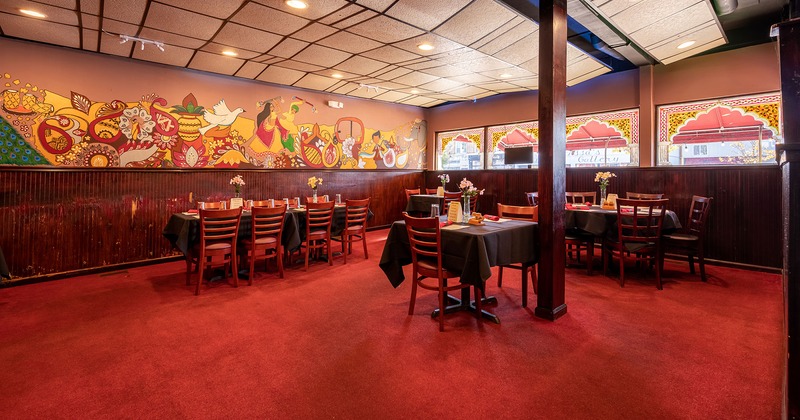 Interior, decorated dining tables, colorful mural art with traditional motifs