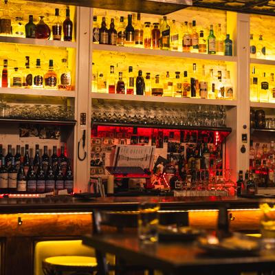 View of the bar with a counter and well-stocked shelves.