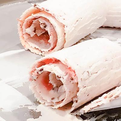 Three pale ice cream rolls on a white surface.