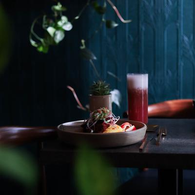 Served food and drink on a table surrounded by plants.