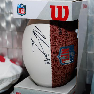 Signed football displayed inside a clear presentation case.