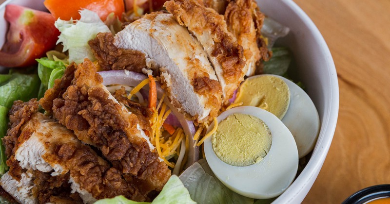 Fried chicken salad with veggies, lettuce, boiled egg