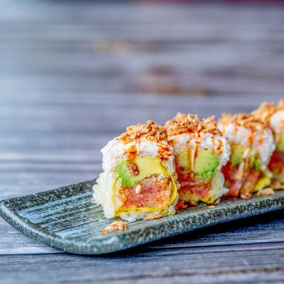 Spicy tuna sushi rolls, topped with crab salad, avocado, and fried onions.