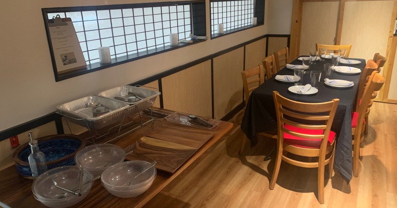 Interior, buffet table with empty trays and bowls, and a table set for dining