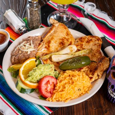 Grilled chicken plate with rice, refried beans, guacamole, and grilled spring onions.