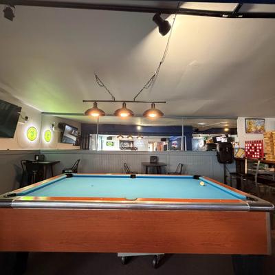 Pool table in a dimly lit bar setting.