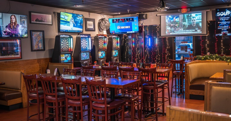 Interior, seating and game area, high wooden tables with stools, dart machines in the back
