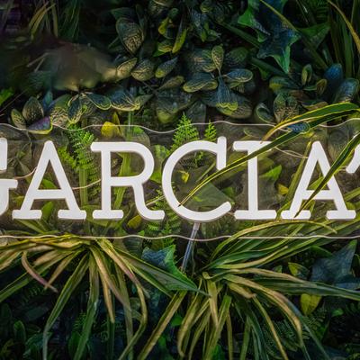 Business name on a green leafy background.