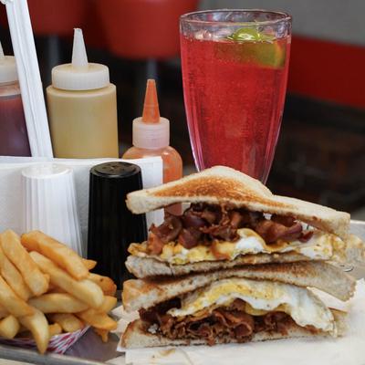 bacon egg and cheese sandwich with french fries and a cherry limeade.