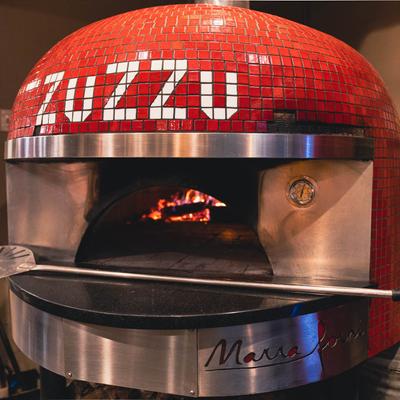 Zuzzu, a pizza oven with a pizza peel.