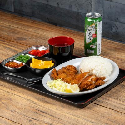 Chicken Katsu served woth rice, salad, sauce, condiments and a canned drink.