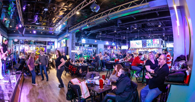 Interior, wide view, tables and chairs, guests dancing