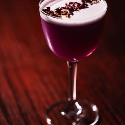 Genie In A Bottle cocktail garnished with dried flower petals.