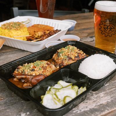 Adobo chicken served with rice, pickles, and a pint of beer.