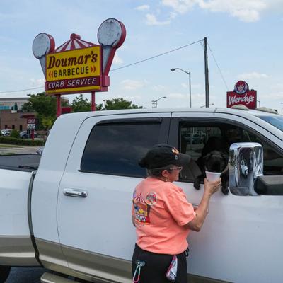 Doumar's sign behind a car receiving curb service.