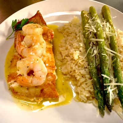 Fish fillet, with shrimp, rice, and asparagus.