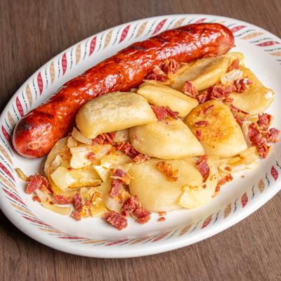 Grilled sausage with pierogis, bacon bits, and onions.