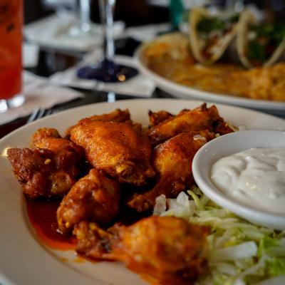 Buffalo wings served with sauce for dipping and lettuce