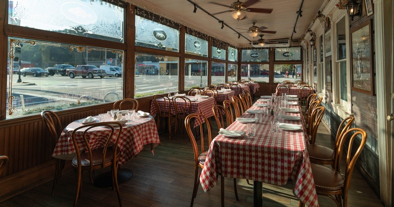 Interior, dining area, checkered red & white cloths on tables, wooden chairs, large windows