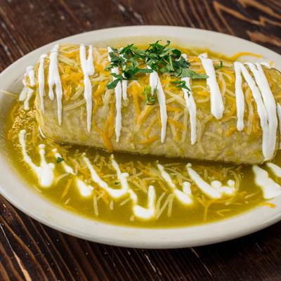 Smothered burrito covered in green sauce and cheese.
