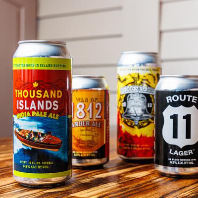 Assorted cans of beer on a wooden table.